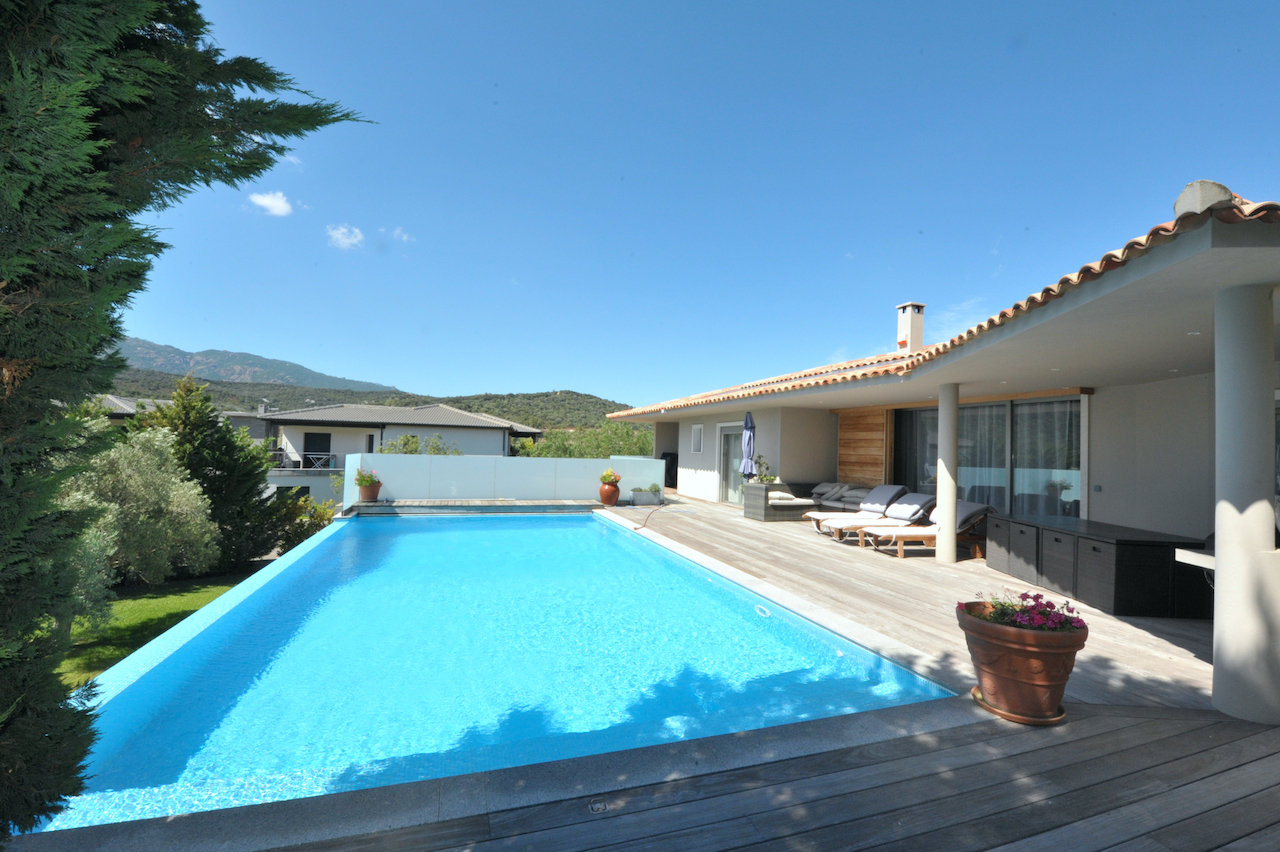 Porto-Vecchio ville: VILLA CONTEMPORAINE T-5 avec jardin, terrasse solarium et PISCINE À DÉBORDEMENT, 2 GRANDS GARAGES, CARPORT/atelier, belle vue dégagée.