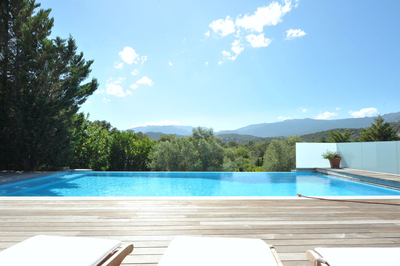 Porto-Vecchio ville: VILLA CONTEMPORAINE T-5 avec jardin, terrasse solarium et PISCINE À DÉBORDEMENT, 2 GRANDS GARAGES, CARPORT/atelier, belle vue dégagée.